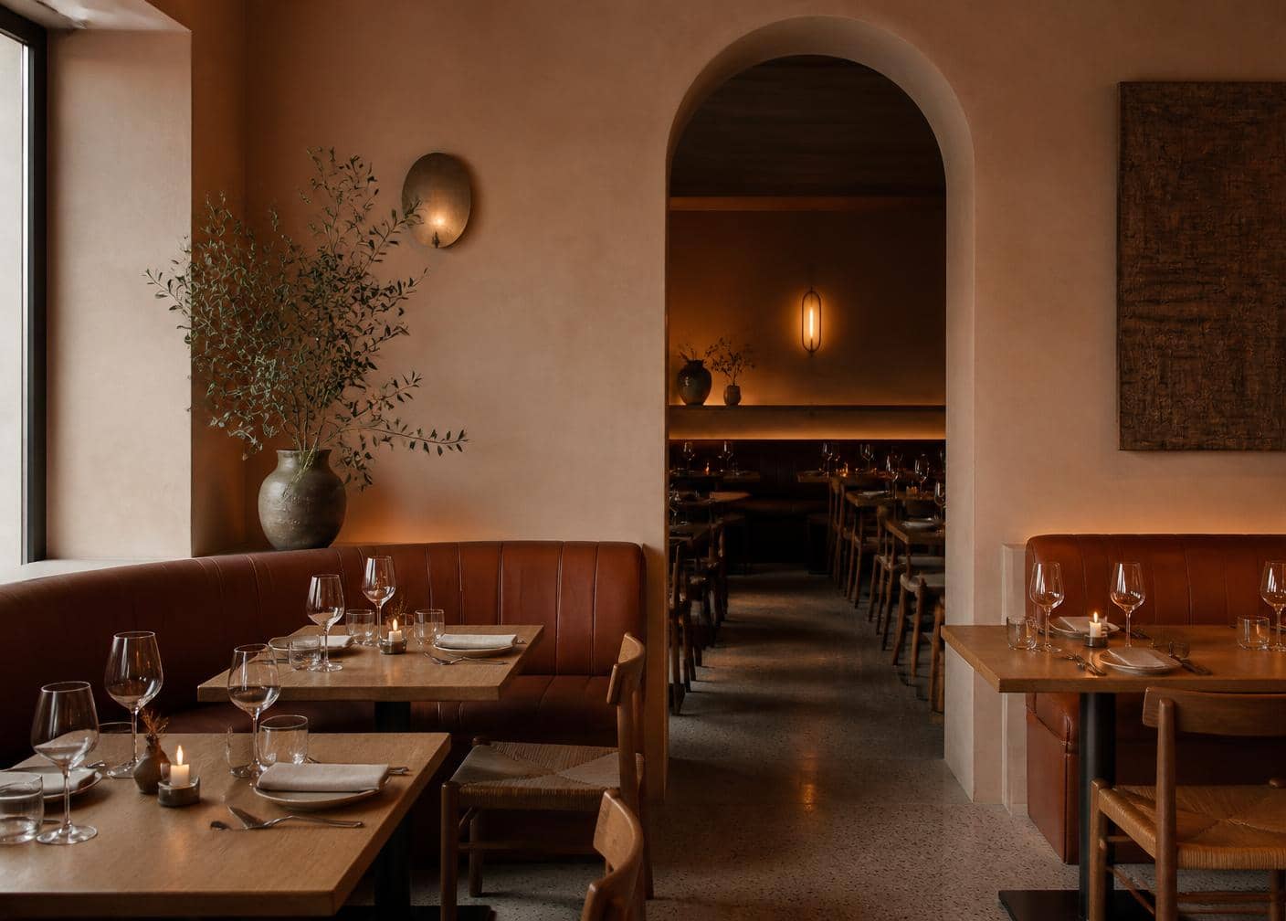 Restaurant mit Ledersitzbänken, gedeckten Tischen und warmem, indirektem Licht
