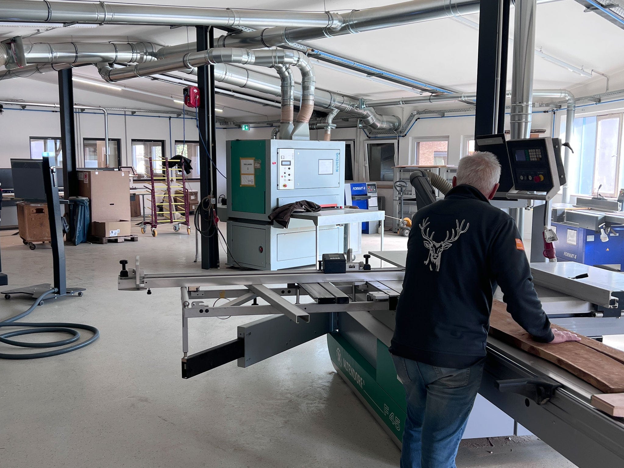Schreiner an der Formatkreissäge in der Werkstatt der Grammlichs