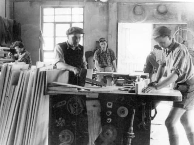 Historische Aufnahme der Schreinerei Grammlich mit Mitarbeitern an der Hobelmaschine