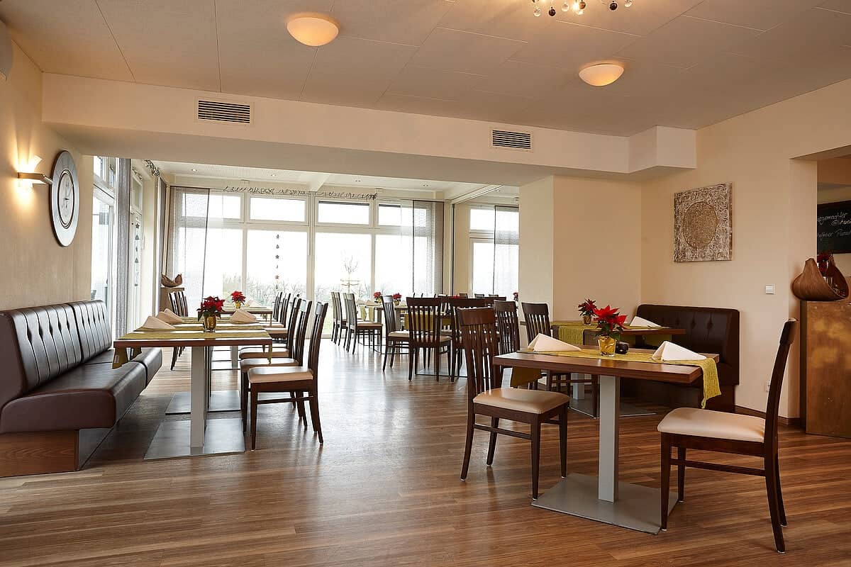 Neu gestaltetes Restaurant des Ferienhofs Michaelsberg mit Holzboden und großen Fenstern